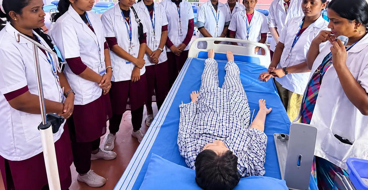 Nursing students practising patient care on a training manikin