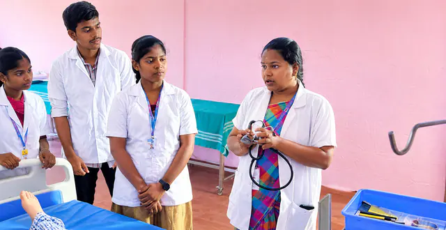 A nursing tutor demonstrating the use of a stethoscope to students