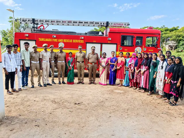 Students with officers of the Tamil Nadu Fire and Rescue Services beside a fire engine